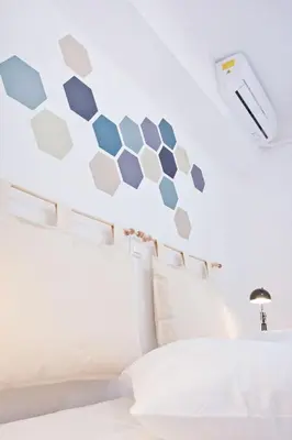 a bedroom with a hexagon wall above a bed at SilkFab Apartments in Athens