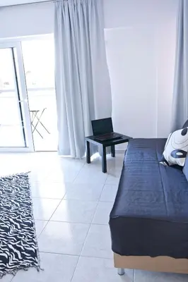 a bedroom with a bed and a chair in a room at SilkFab Apartments in Athens