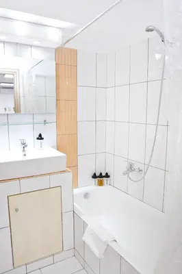 a white bathroom with a tub and a sink at SilkFab Apartments in Athens