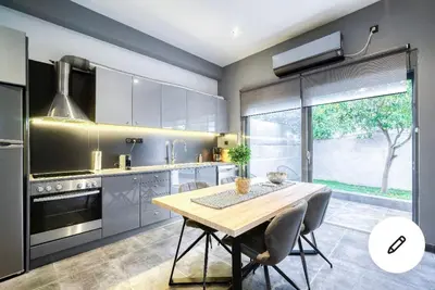 a kitchen with a wooden table and chairs in it at L apartment in Athens