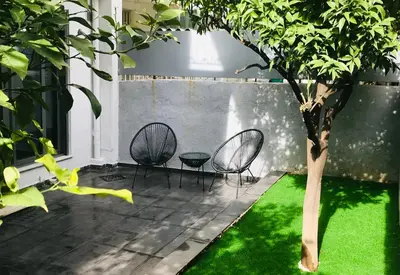 a patio with two chairs and a tree at L apartment in Athens