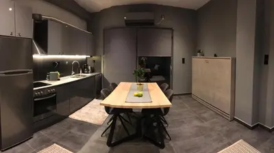 a kitchen with a wooden table in the middle of it at L apartment in Athens