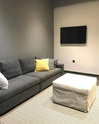 a living room with a gray couch and a tv at L apartment in Athens