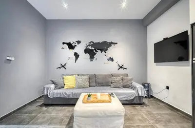 a living room with a couch and a world map on the wall at L apartment in Athens