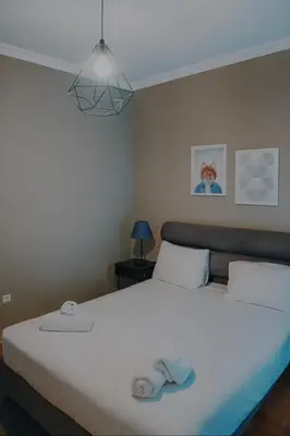 a bedroom with a bed with two towels on it at Mignon & Teak Apartments in Athens