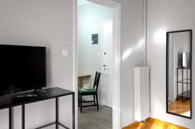 a living room with a television and a mirror at Mignon & Teak Apartments in Athens