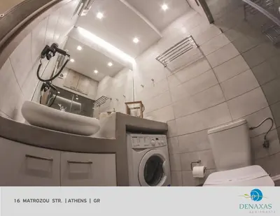 a bathroom with a sink and a washing machine at Denaxas Apartments in the heart of Athens in Athens
