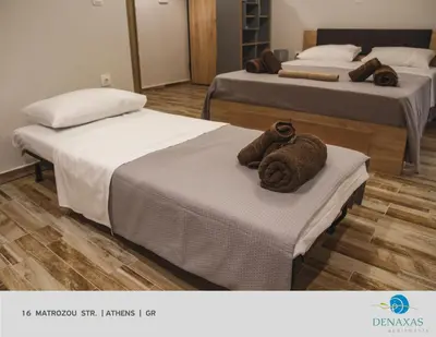 two beds in a room with towels on them at Denaxas Apartments in the heart of Athens in Athens