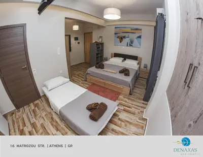 a large room with two beds and a mirror at Denaxas Apartments in the heart of Athens in Athens