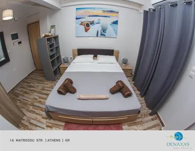 a bedroom with a bed and two pairs of shoes at Denaxas Apartments in the heart of Athens in Athens