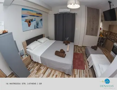 a bedroom with a large white bed in a room at Denaxas Apartments in the heart of Athens in Athens