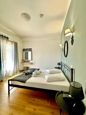 a bedroom with a large bed and a table at Sparta Team Hotel in Athens