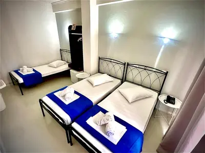 two beds in a room with blue and white sheets at Sparta Team Hotel in Athens