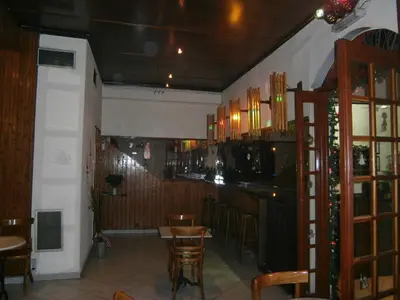 a restaurant with a bar and some tables and chairs at Sparta Team Hotel in Athens