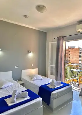two beds in a room with a balcony at Sparta Team Hotel in Athens