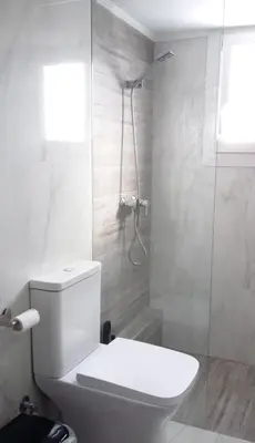 a white bathroom with a toilet and a shower at Krezias Apartments E7 in Athens