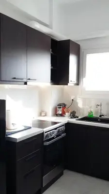 a kitchen with black cabinets and a sink at Krezias Apartments E7 in Athens
