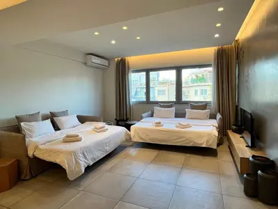 a hotel room with two beds and a tv at *** Apt 110m2 3bed 2bath, walk to Acropolis *** in Athens