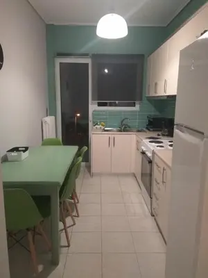 a kitchen with a table and a kitchen with green walls at Athenian Luxury apartment, near metro station Chalandri, Nu 2 in Athens