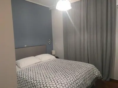 a bedroom with a bed with white sheets and a window at Athenian Luxury apartment, near metro station Chalandri, Nu 2 in Athens
