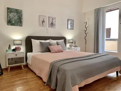a bedroom with a large bed and a window at Nadia's apartment , Athens in Athens