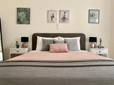 a bedroom with a large bed with three pictures on the wall at Nadia's apartment , Athens in Athens