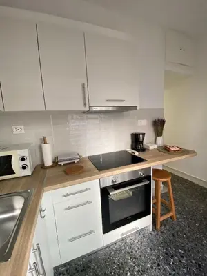 a kitchen with white cabinets and a sink and a stove at Nadia's apartment , Athens in Athens