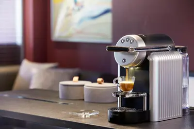 a coffee maker sitting on a counter with a cup of coffee at Athens Ikon in Athens