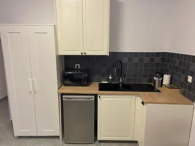 a kitchen with white cabinets and a sink at Connect Suites in Athens