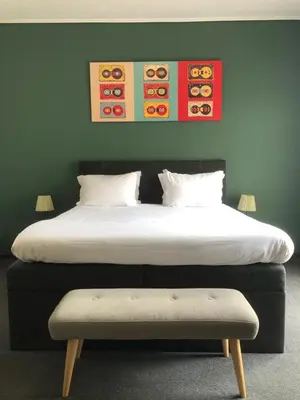 a bedroom with two beds with a bench in front at Connect Suites in Athens