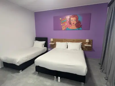 a room with two beds and a painting on the wall at Connect Suites in Athens