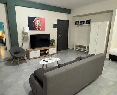 a living room with a couch and a tv at Connect Suites in Athens