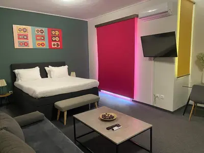 a room with a bed and a couch and a tv at Connect Suites in Athens
