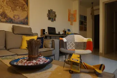 a living room with a couch and a table at Georgina's cozy apartment -Metropolitan Hospital- in Piraeus