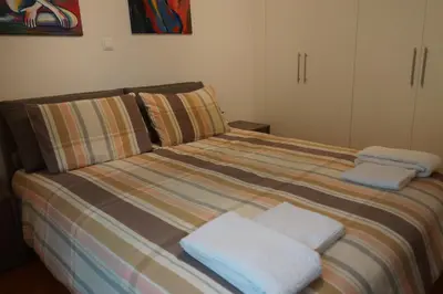 a bedroom with a bed with two towels on it at Georgina's cozy apartment -Metropolitan Hospital- in Piraeus