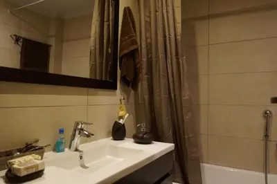 a bathroom with a sink and a shower curtain at Georgina's cozy apartment -Metropolitan Hospital- in Piraeus