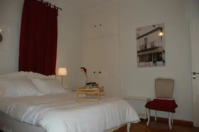 a bedroom with a bed with a table and a chair at Soulis' penthouse near Acropolis in Athens