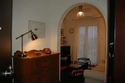 a living room with an archway and a room with a couch at Soulis' penthouse near Acropolis in Athens