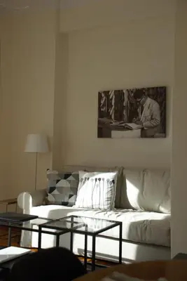 a living room with a white couch and a glass table at Soulis' penthouse near Acropolis in Athens