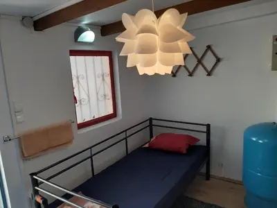 a bed in a room with a window and a chandelier at Country Rooms near Athens - Airport in Vravrona