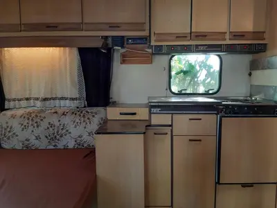 a kitchen in an rv with a stove and a bed at Country Rooms near Athens - Airport in Vravrona