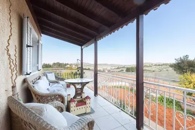 a porch with wicker chairs and a table on a balcony at Country Rooms near Athens - Airport in Vravrona