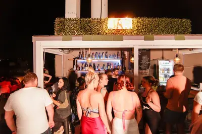 a group of people standing outside of a bar at Athens Hawks in Athens