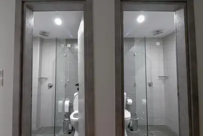 a bathroom with two toilets and glass showers at Athens Hawks in Athens