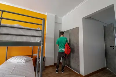 a man standing in a bedroom with a bunk bed at Athens Hawks in Athens