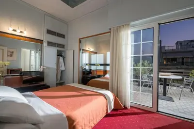 a hotel room with two beds and a balcony at Victory Inn Hotel in Athens
