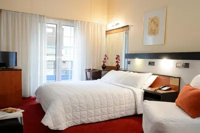 a hotel room with two beds and a television at Victory Inn Hotel in Athens
