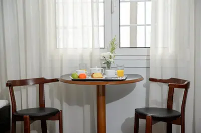 a table with a plate of food and two chairs at Victory Inn Hotel in Athens