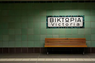 a bench in a building with a sign on a wall at Victory Inn Hotel in Athens