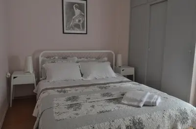 a bedroom with a bed with a blanket and two tables at Awesome Home 3' from Metro (M3) Station Agia Paraskevi in Athens